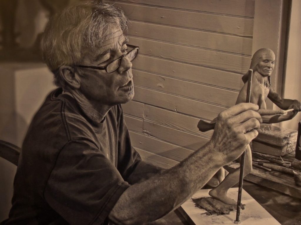 Jud Hartmann sculpting a clay figure.